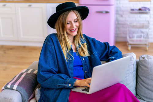 Stylish-Blogger-Woman-Using-Her-Laptop-Sitting-Sofa-Living-Room-Home-Office-Trendy-Outfit-New