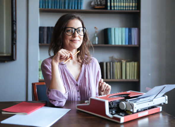 Cursuri 435 Portrait-Mature-Smiling-Authoress-Sitting-Desk