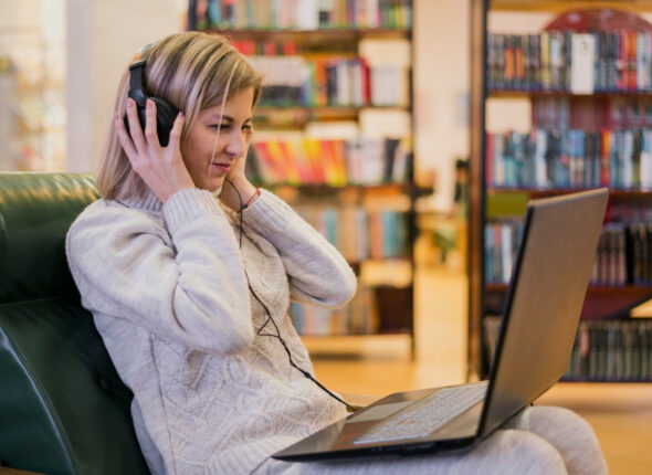 Cursuri 419 Woman-Wearing-Headphones-Looking-Laptop